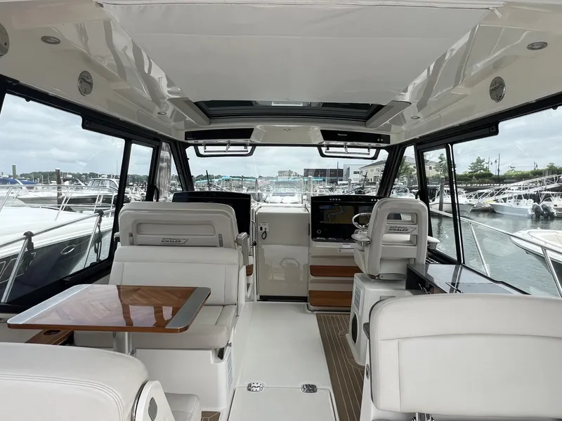 Slide: The Image of Interior of 2021 Boston Whaler 405 Conquest yacht with luxurious seating and marina view. - 6