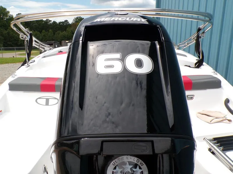 Slide: The Image of 2024 Tahoe T16 boat with Mercury 60 engine, docked near a blue building. - 5
