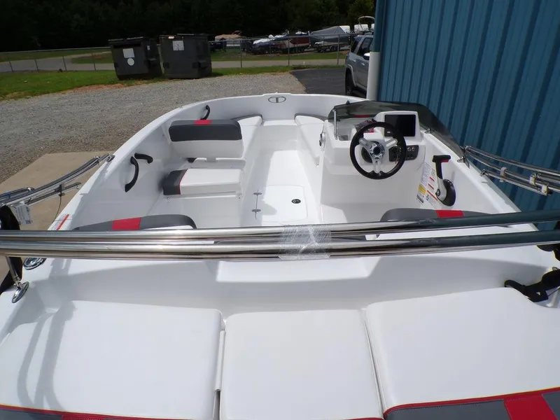 Slide: The Image of 2024 Tahoe T16 boat interior with seating and steering console, parked outdoors. - 6