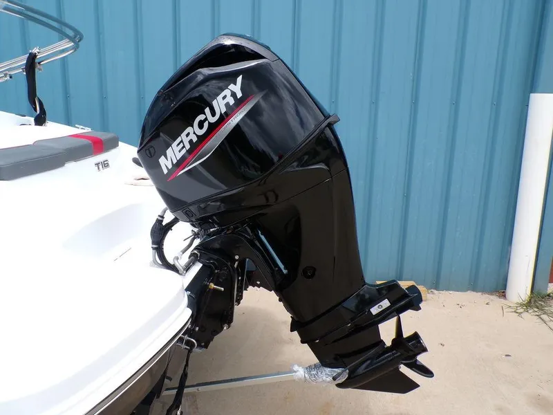 Slide: The Image of 2024 Tahoe T16 boat with Mercury outboard motor, parked near blue wall. - 8