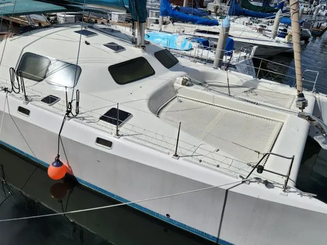 Slide: The Image of 2000 Ocean Cat 49 catamaran docked at marina, white hull, spacious deck. - 19
