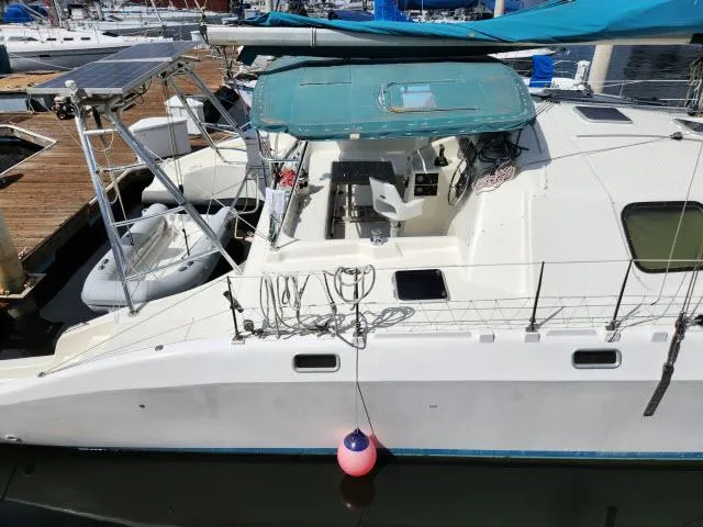 Slide: The Image of 2000 Ocean Cat 49 catamaran docked at marina with solar panels and dinghy. - 21