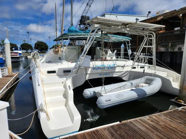 Slide: The Image of Ocean Cat 49 catamaran, 2000 model, docked with inflatable dinghy at marina. - 24