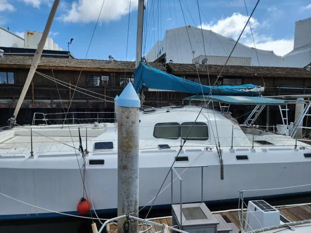 Slide: The Image of 2000 Ocean Cat 49 catamaran docked at marina with blue sky background. - 25