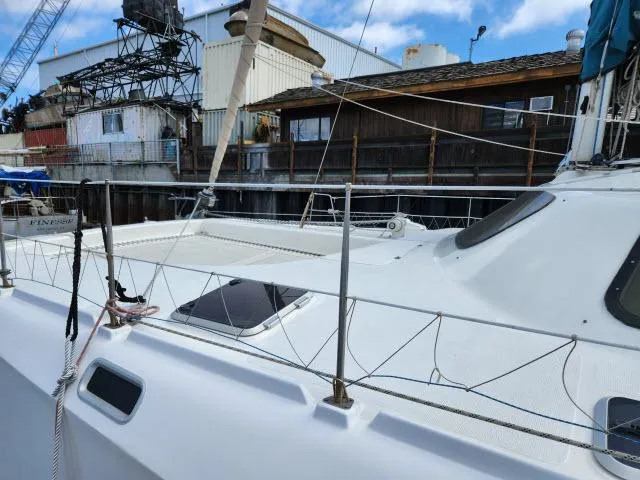 Slide: The Image of 2000 Ocean Cat 49 sailboat docked near industrial buildings. - 26