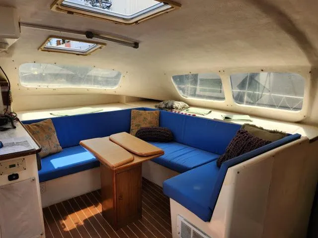 Slide: The Image of Interior of a 2000 Ocean Cat 49 catamaran with blue seating and wooden table. - 32