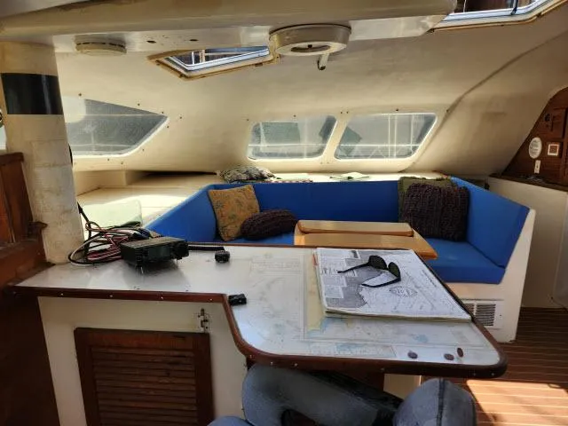 Slide: The Image of Interior of a 2000 Ocean Cat 49 catamaran with blue seating and navigation table. - 35