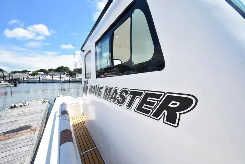 Slide: The Image of 2023 Custom Aljerewy Wave Master boat docked at marina under blue sky. - 20