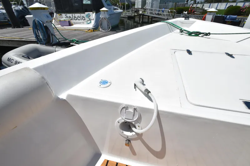 Slide: The Image of Custom 2023 Aljerewy Wave Master boat deck with hose and docked boats in background. - 23
