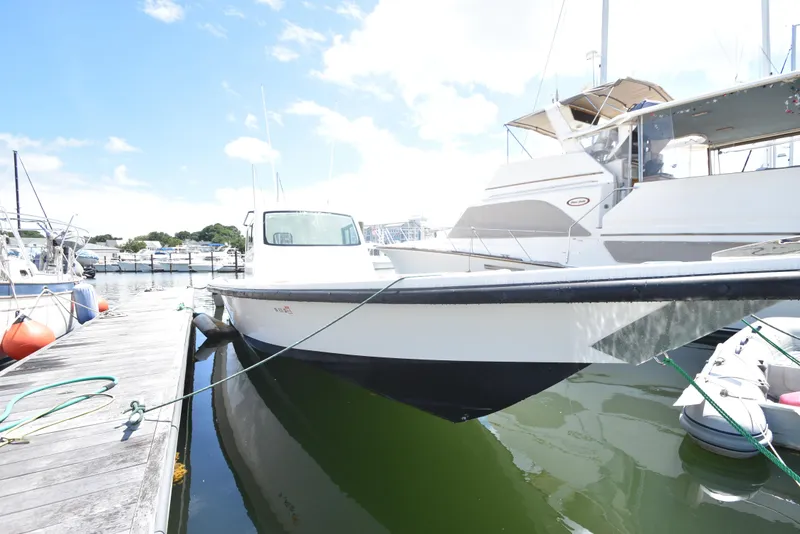 Slide: The Image of 2023 Custom Aljerewy Wave Master boat docked at a marina on a sunny day. - 26
