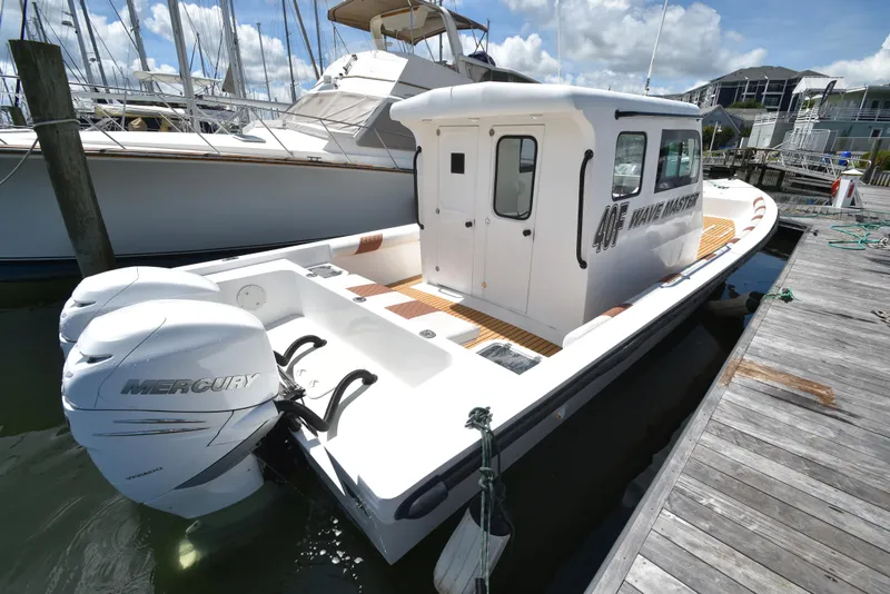 Slide: The Image of Custom 2023 Aljerewy Wave Master boat docked, featuring twin Mercury outboard engines. - 27
