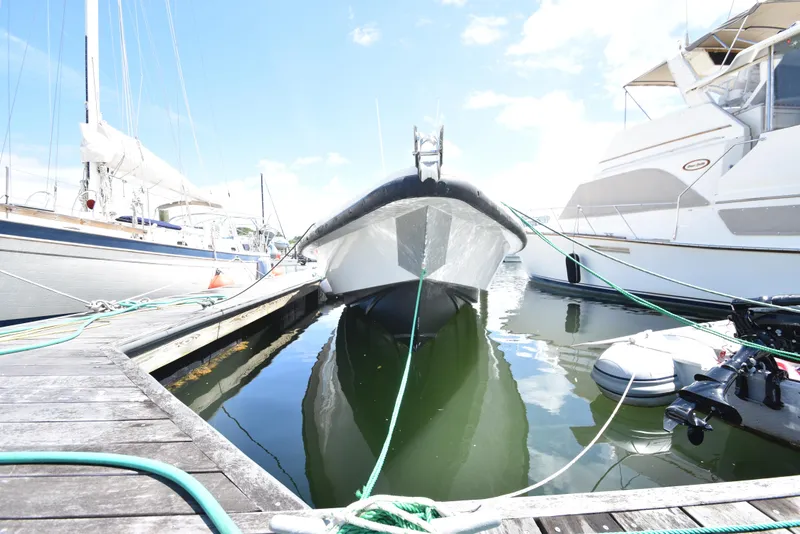 Slide: The Image of 2023 Custom Aljerewy Wave Master boat docked at marina, surrounded by other vessels. - 4