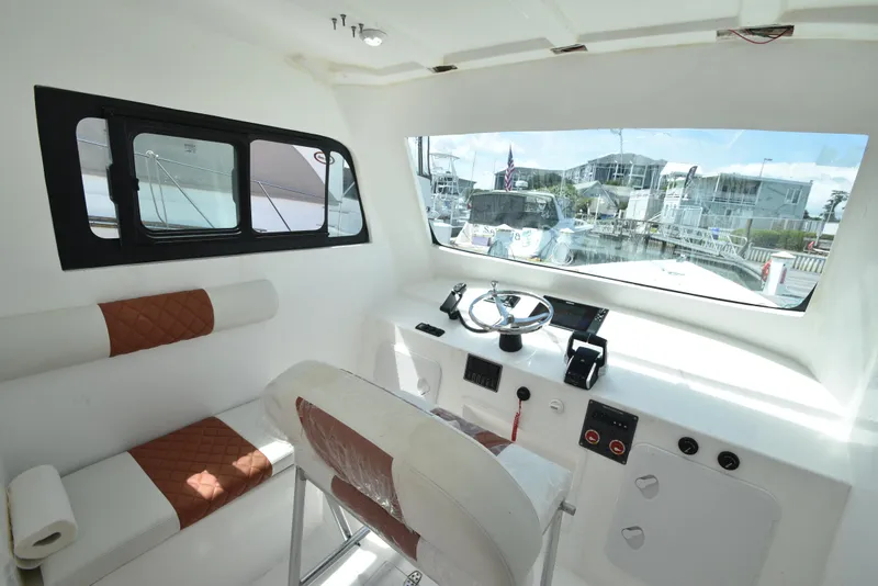 Slide: The Image of Interior of 2023 Custom Aljerewy Wave Master boat with steering wheel and seating. - 8