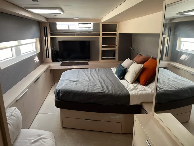 Slide: The Image of Luxurious 2021 Lagoon 55 yacht bedroom with modern decor and ample storage. - 13