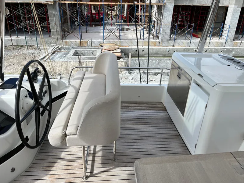 Slide: The Image of Lagoon 55 yacht interior with helm, seating, and kitchenette, 2021 model. - 7