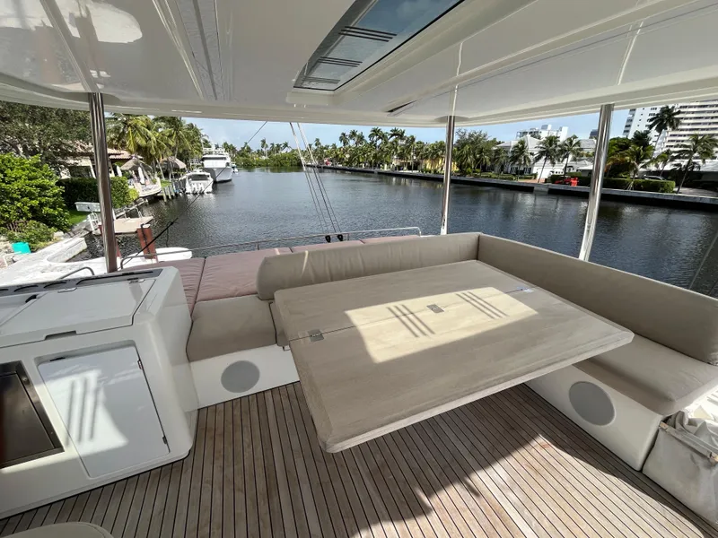 Slide: The Image of Lagoon 55 yacht interior, 2021 model, featuring spacious seating and scenic waterway view. - 9