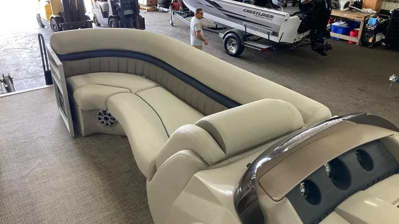 Slide: The Image of 2019 Bennington 23 GSB pontoon boat with beige and gray seating in a showroom. - 13