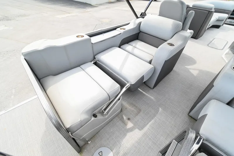 Slide: The Image of 2022 Manitou 25 Oasis VP boat interior with gray seating and cup holders. - 10