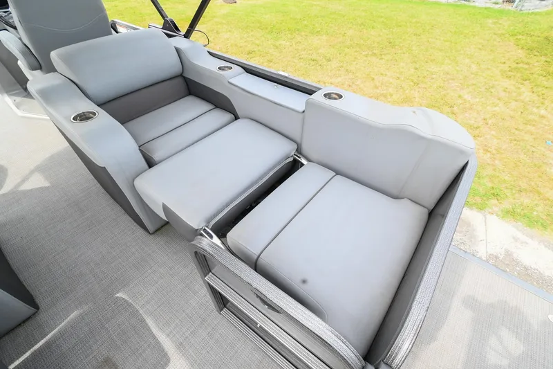 Slide: The Image of 2022 Manitou 25 Oasis VP boat interior with gray seating and cup holders. - 13