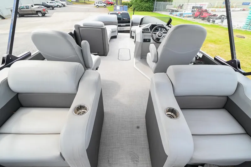 Slide: The Image of 2022 Manitou 25 Oasis VP boat interior with plush gray seating and cup holders. - 16