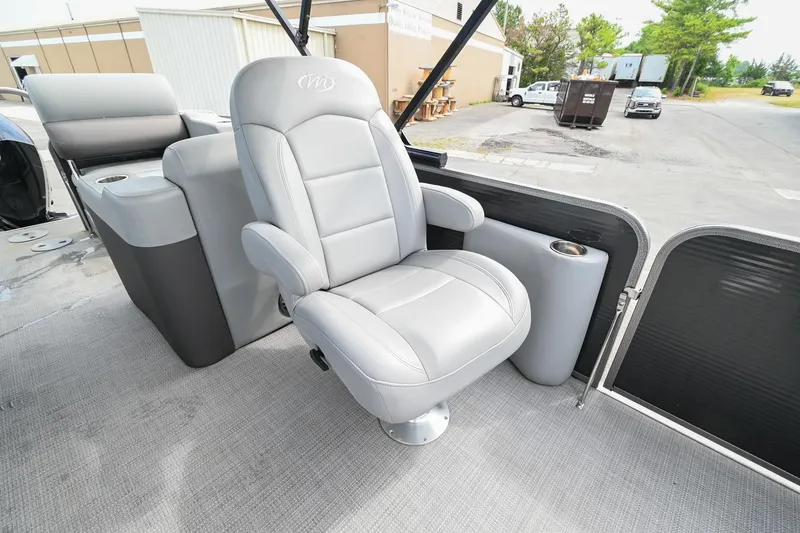 Slide: The Image of 2022 Manitou 25 Oasis VP boat interior with plush gray seating and cup holder. - 18