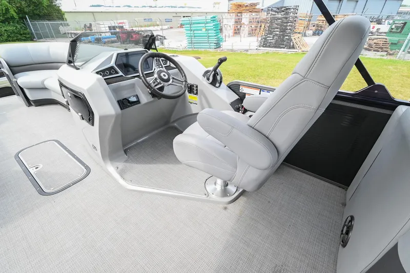 Slide: The Image of 2022 Manitou 25 Oasis VP boat interior with steering console and captain's chair. - 19