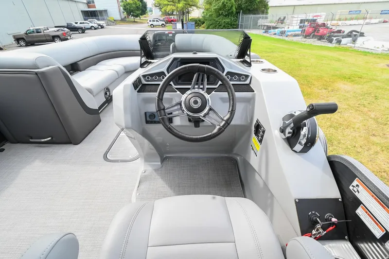 Slide: The Image of 2022 Manitou 25 Oasis VP boat interior with steering wheel and seating area. - 20