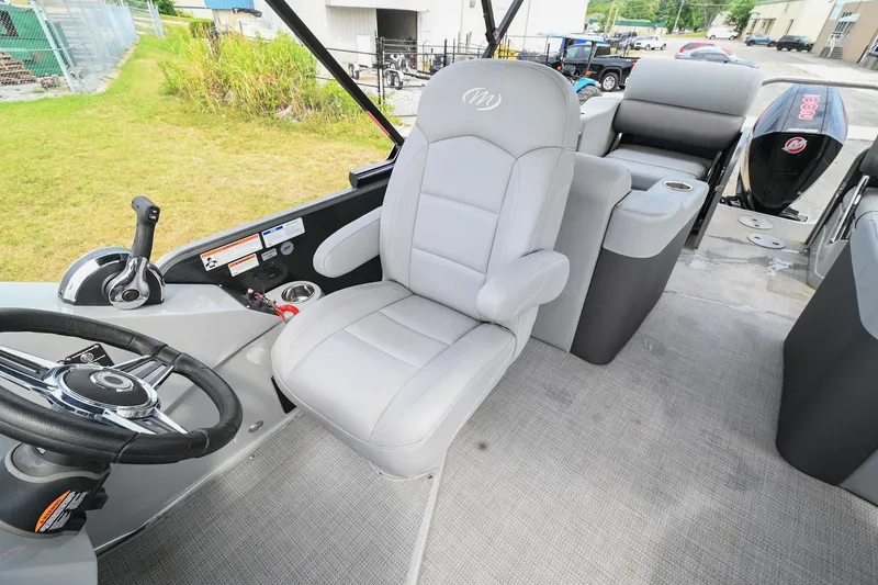 Slide: The Image of 2022 Manitou 25 Oasis VP boat interior with gray captain's chair and steering wheel. - 21