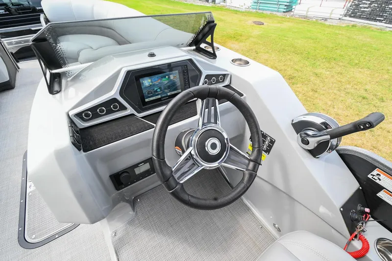 Slide: The Image of 2022 Manitou 25 Oasis VP boat dashboard with steering wheel and control panel. - 23