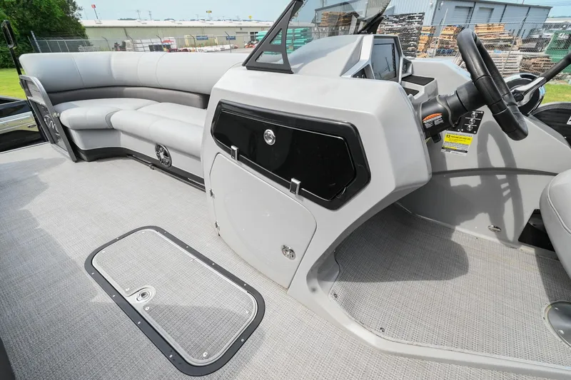 Slide: The Image of 2022 Manitou 25 Oasis VP boat interior with sleek seating and modern dashboard design. - 27
