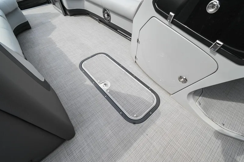 Slide: The Image of 2022 Manitou 25 Oasis VP boat interior with carpeted flooring and storage compartment. - 28