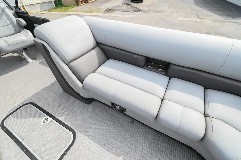 Slide: The Image of 2022 Manitou 25 Oasis VP boat interior with gray cushioned seating and cup holders. - 32