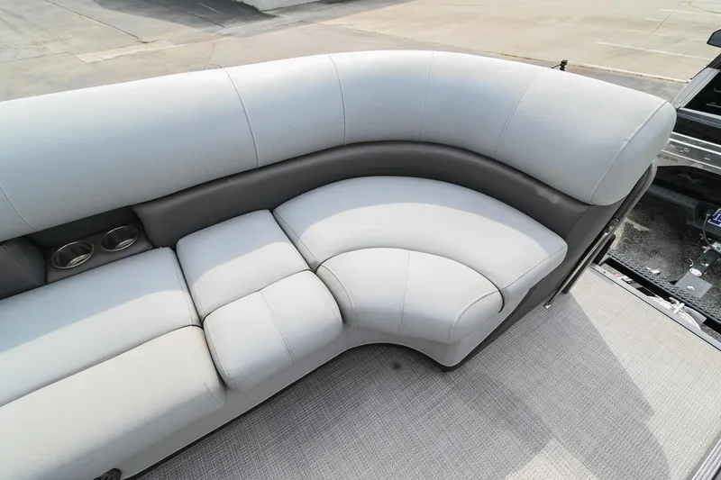 Slide: The Image of 2022 Manitou 25 Oasis VP boat with luxurious gray seating and cup holders. - 33