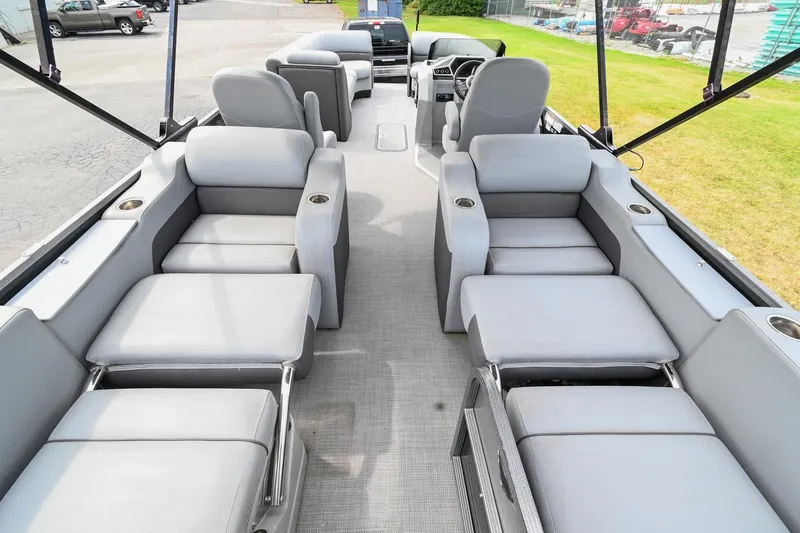 Slide: The Image of 2022 Manitou 25 Oasis VP pontoon boat interior with gray seating and cup holders. - 5