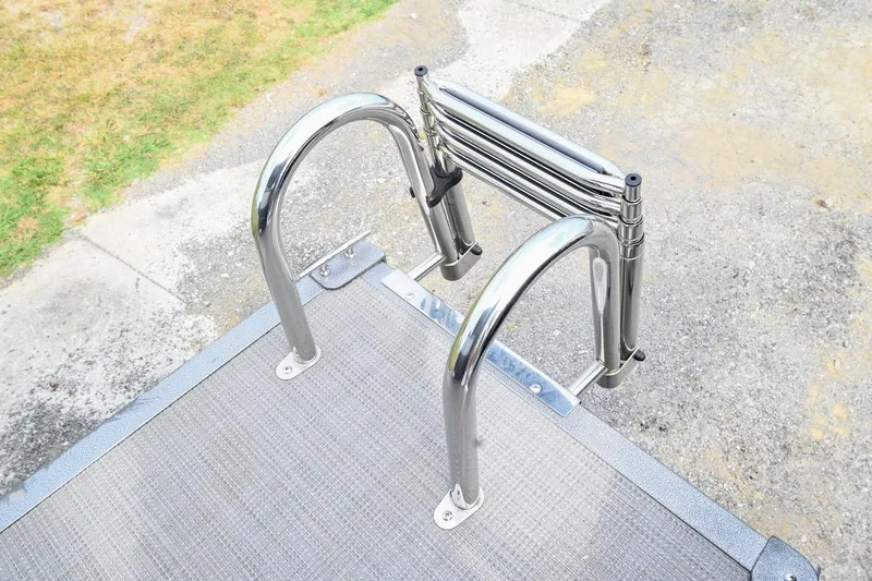 Slide: The Image of 2022 Manitou 25 Oasis VP boat ladder with stainless steel rails on a dock. - 7