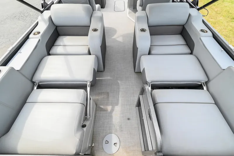 Slide: The Image of 2022 Manitou 25 Oasis VP boat interior with gray seating and cup holders. - 9
