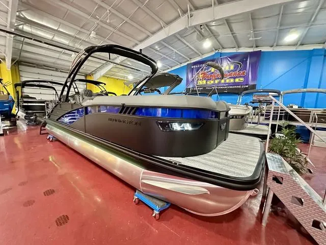 Slide: The Image of 2025 Bennington 24 LXSBA pontoon boat in showroom. - 2