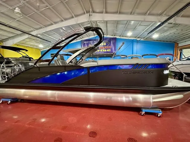 Slide: The Image of 2025 Bennington 24 LXSBA pontoon boat in showroom, sleek black and blue design. - 33