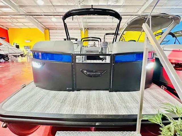 Slide: The Image of 2025 Bennington 24 LXSBA pontoon boat in showroom with luxurious seating. - 4