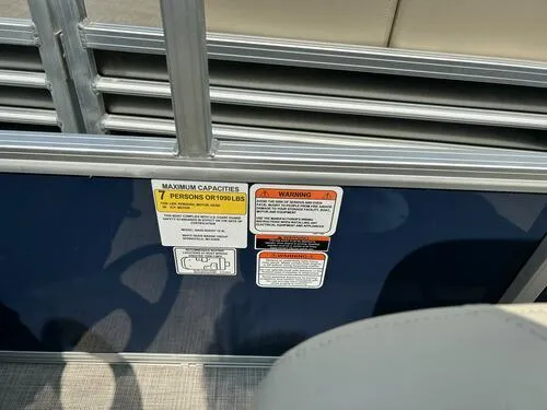 Slide: The Image of Capacity and warning labels on 2025 Sun Tracker Bass Buggy 16 XL Select pontoon boat. - 12
