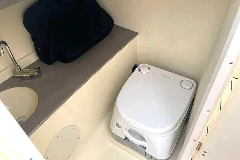 Slide: The Image of 2022 Chris-Craft Launch 27 interior bathroom with portable toilet and sink. - 14