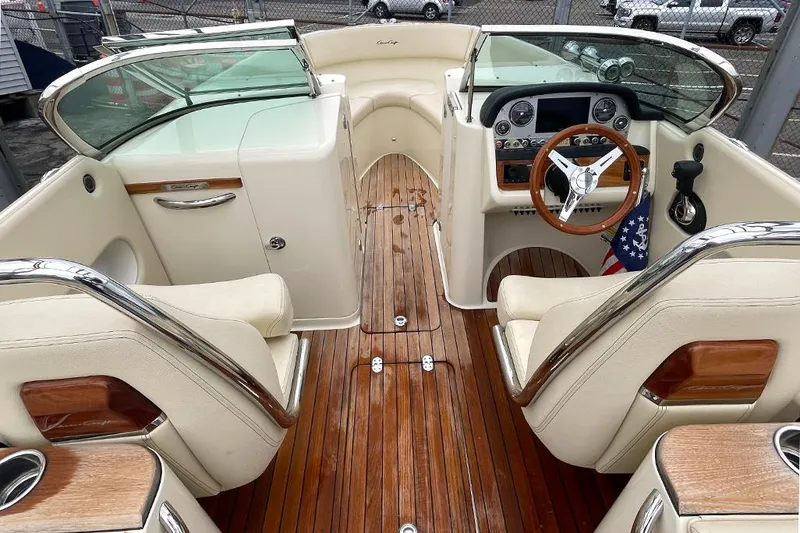 Slide: The Image of 2022 Chris-Craft Launch 27 boat interior with wooden deck and cream leather seats. - 6