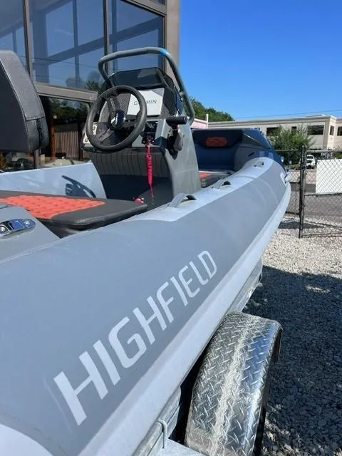 Slide: The Image of 2024 Highfield Sport 460 boat on a trailer, close-up view of the interior and steering console. - 2