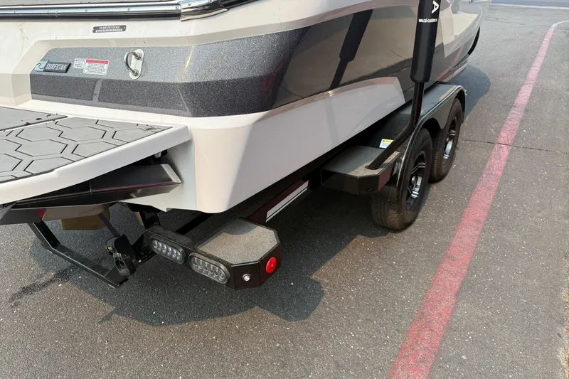 Slide: The Image of 2024 MasterCraft NXT23 boat trailer with dual axles and rear platform detail. - 11