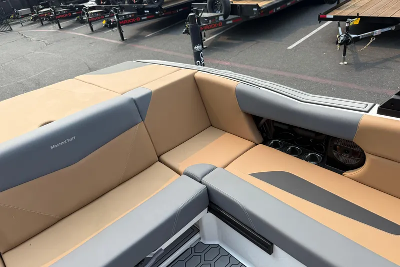 Slide: The Image of 2024 MasterCraft NXT23 boat interior with tan and gray seating. - 19