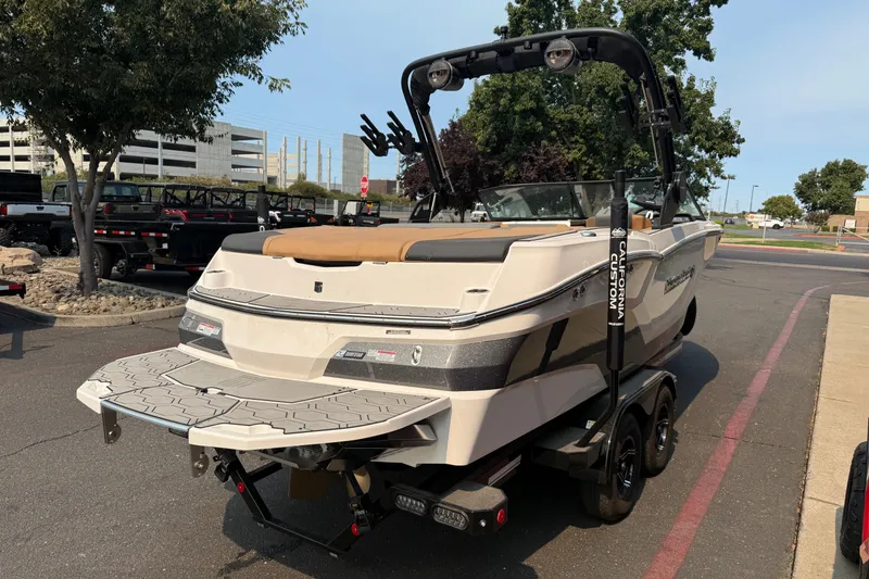 Slide: The Image of 2024 MasterCraft NXT23 boat on trailer, parked outdoors, rear view. - 5