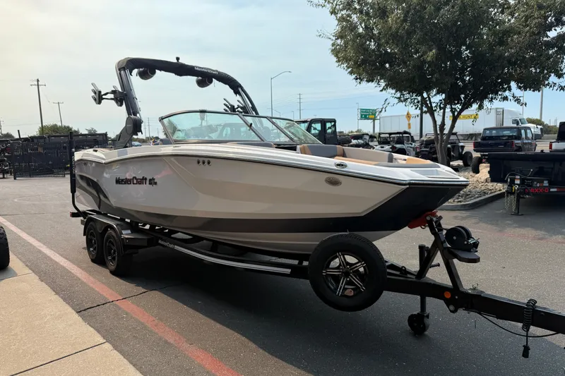 Slide: The Image of 2024 MasterCraft NXT23 boat on trailer in parking lot, side view. - 6