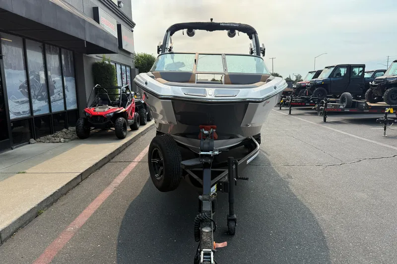 Slide: The Image of 2024 MasterCraft NXT23 boat on trailer, parked outside dealership. - 7