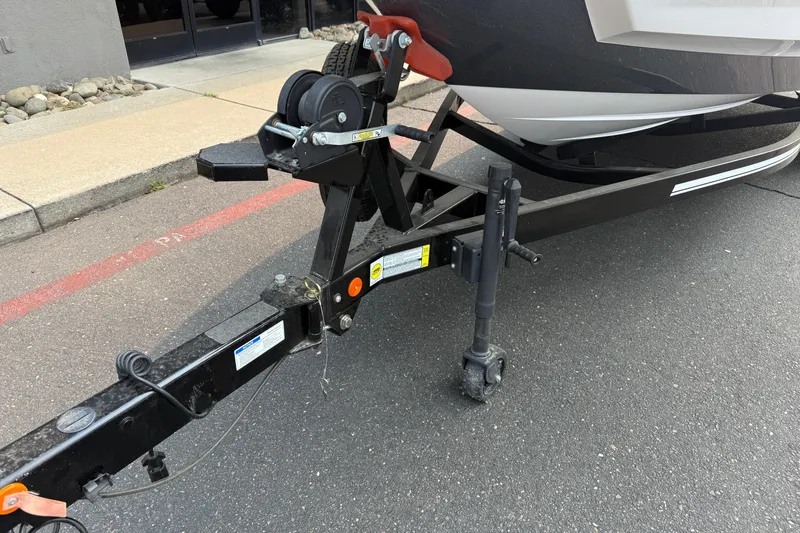 Slide: The Image of 2024 MasterCraft NXT23 boat trailer hitch on pavement, showcasing sturdy construction. - 8