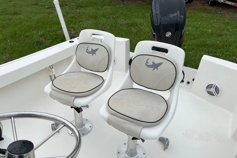 Slide: The Image of 2015 Mako 184 CC boat interior with two cushioned seats and steering wheel. - 11